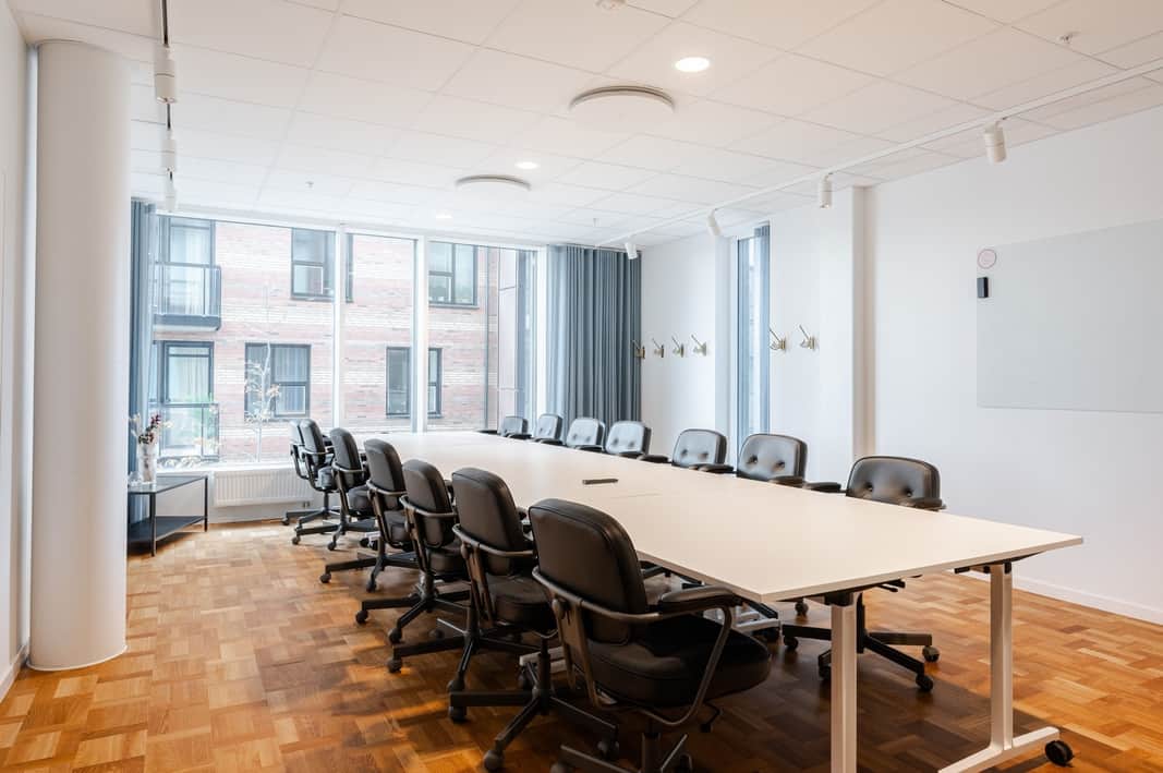 Ett konferensrum med ett långt bord och stolar.