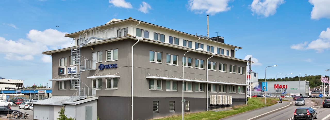 En stor grå byggnad som ligger vid sidan av en väg.