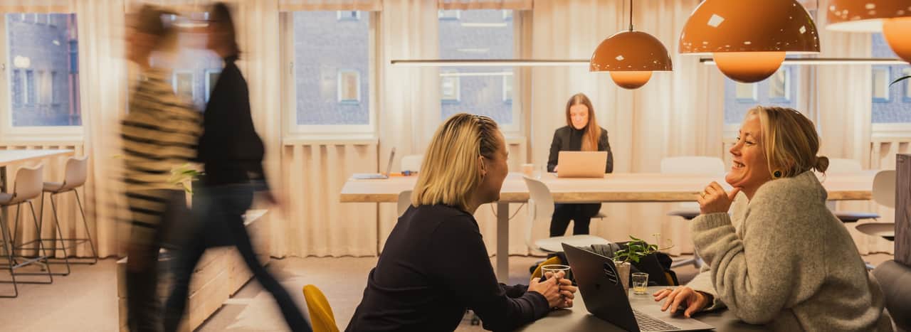 Vy över öppen yta med sittbänkar mot vägg.