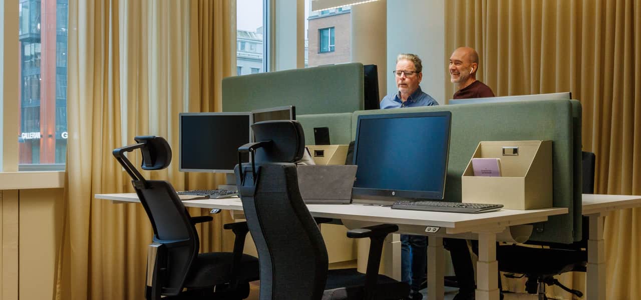 Två personer jobbar vid ståbord