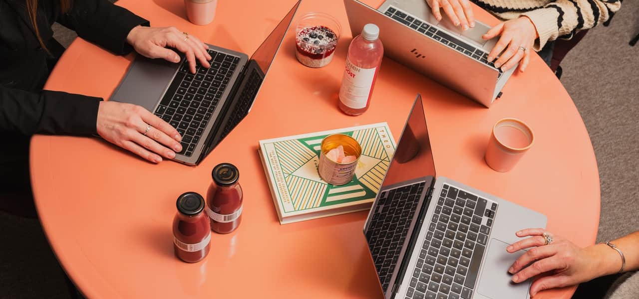 Tre laptops på ett bord och diverse godsaker