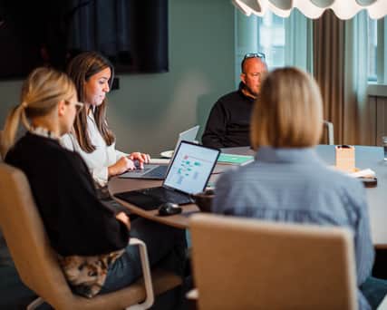 Tre personer samtalar vid ett bord.