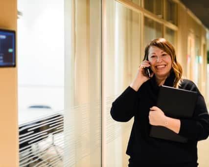 Person går i korridor talandes i telefon