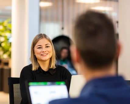 Två personer som sitter mittemot varandra med varsin dator.