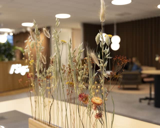 Torkade blommor som är nedstuckna i en avlång träbit