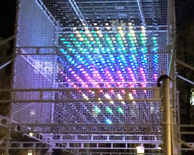 Ljusinstallation i olika färger på en byggställning