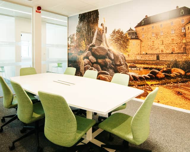 Litet konferensrum med gröna stolar och fototapet med Örebro slott