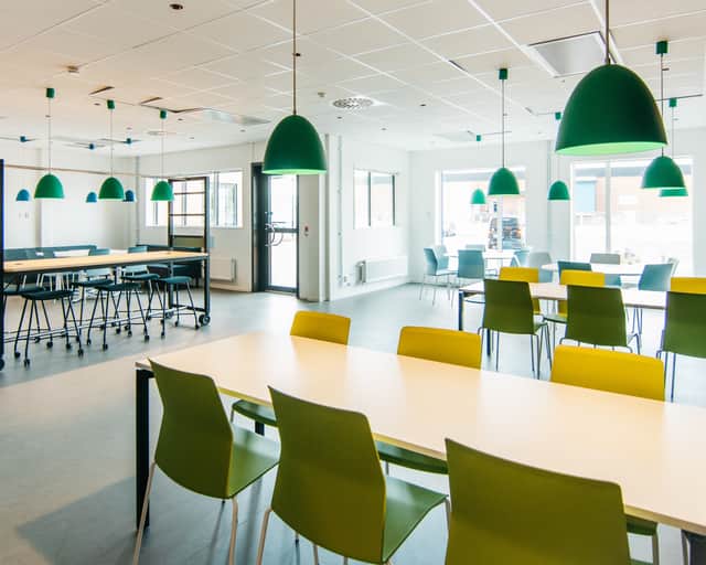 Pausrum med färgglada stolar i gult och gröna taklampor