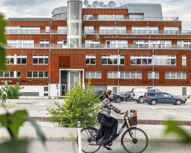 Tegelfastighet med en cyklist som åker förbi.