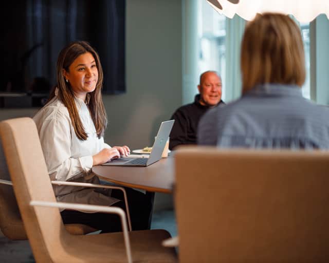Tre personer sitter och samtalar i ett möte