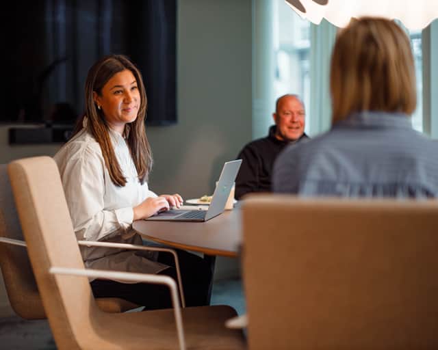 Två personer sitter och samtalar med en laptop i knät