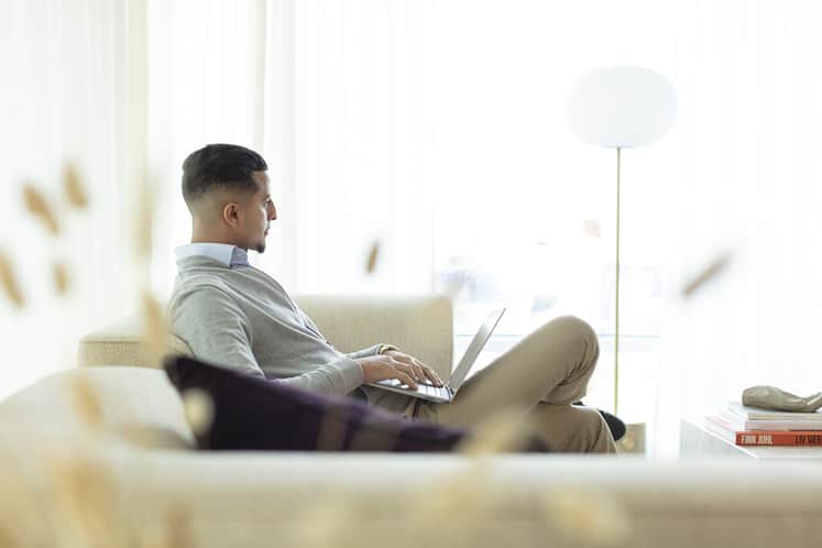 Person med laptop i soffa.