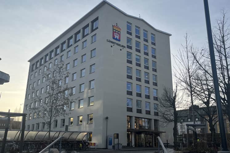 Vit fastighet med många små fönster 