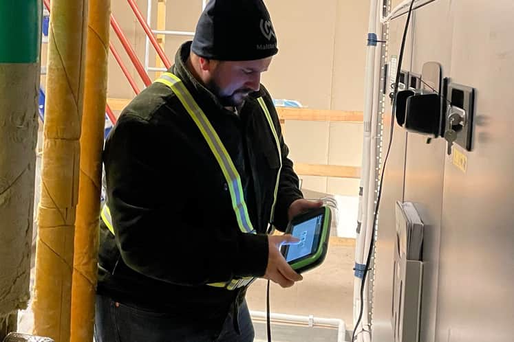 Medarbetare som står vid en undercentral och gör inställningar