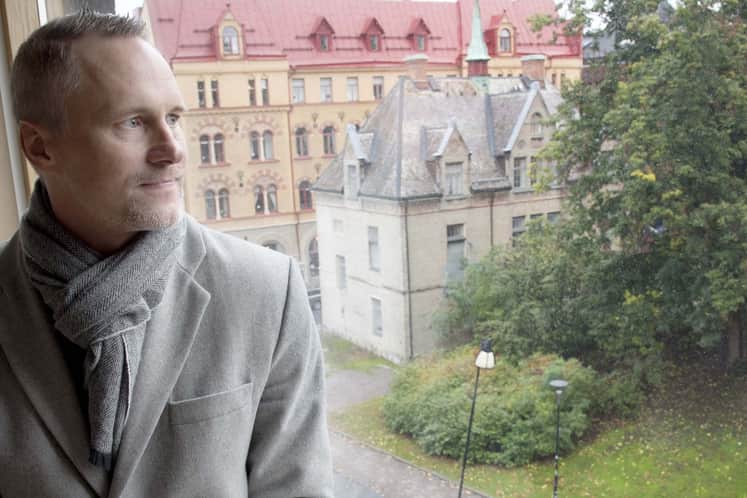 Göran sitter i en fönsterkarm och blickar ut.