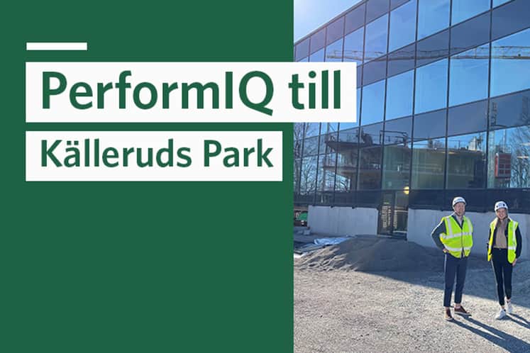 Två personer i skyddsvästar framför fastigheten.