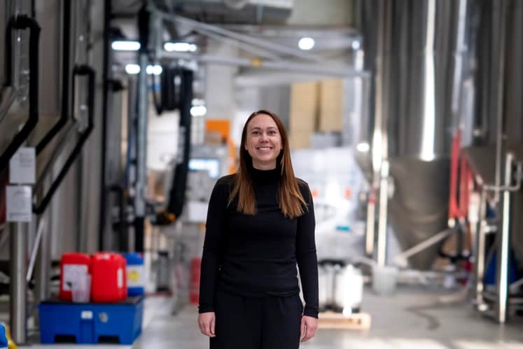Stigbergets Bryggeris VD Marie Ejdestig i bryggerilokalen med öltankar i bakgrunden