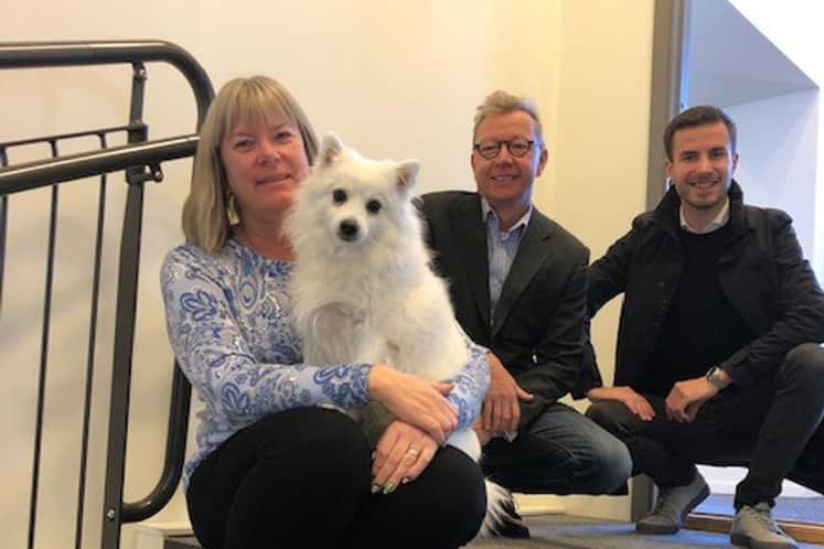 Företagets medarbetare och en hund i trapphuset.