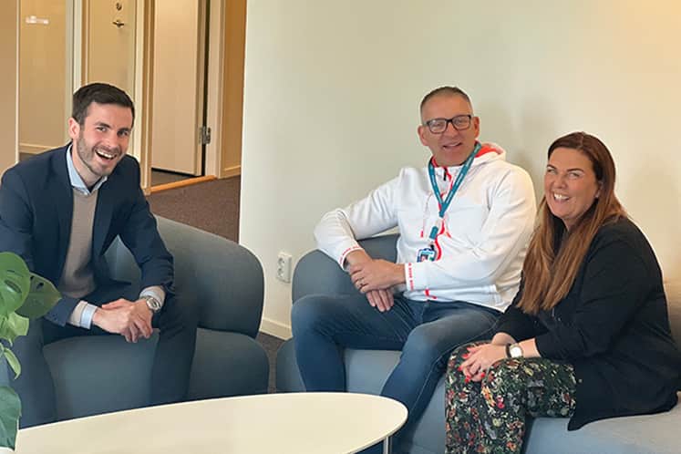 Tre personer som sitter i en soffgrupp.