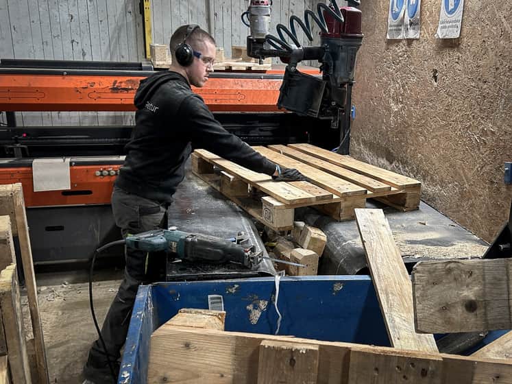 En person arbetar med pallar