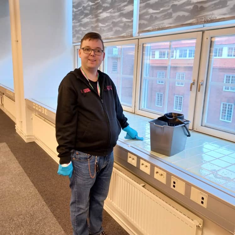 Johan Annell dammtorkar fönsterbrädor.