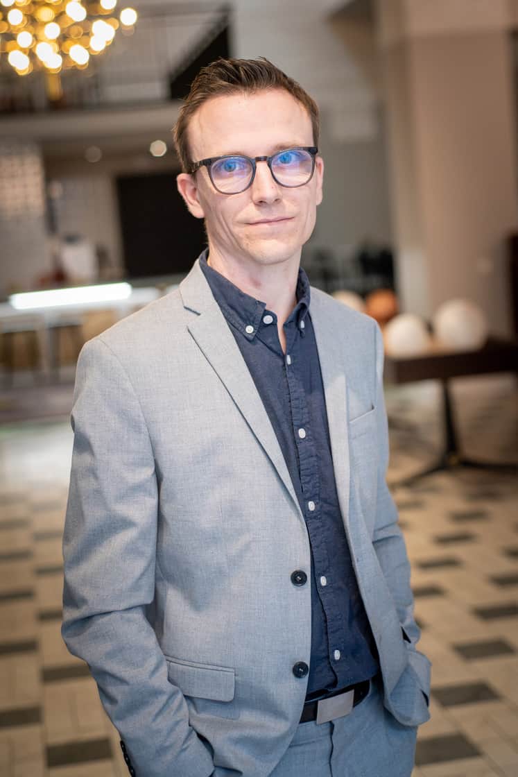 Man i grå kostym och glasögon