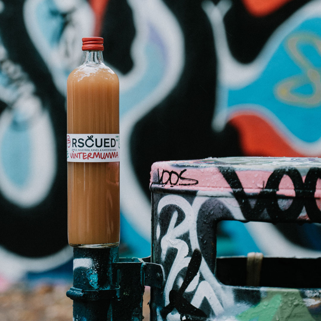 Juiceflaska framför graffitivägg.