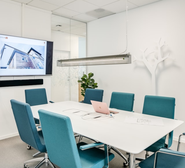 Mindre konferensrum med stolar runt ett bord och en tv-skärm på väggen
