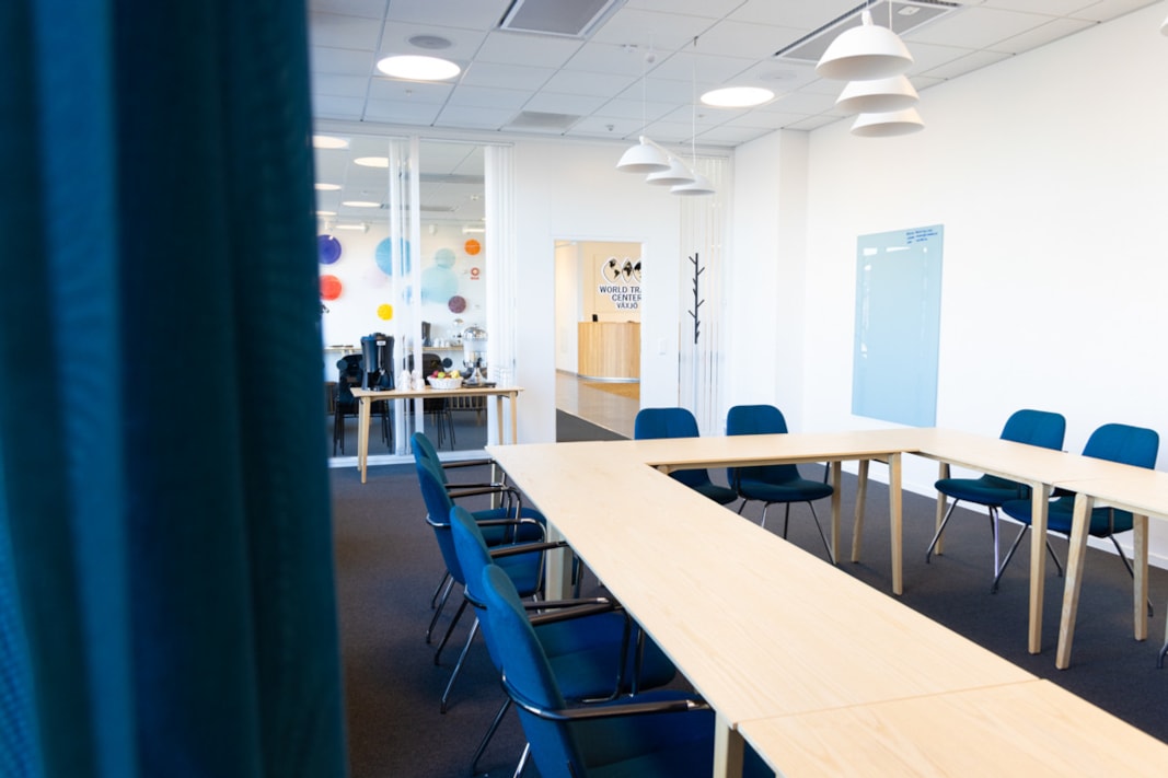 Konferensrum med blå stolar och ljusa bord