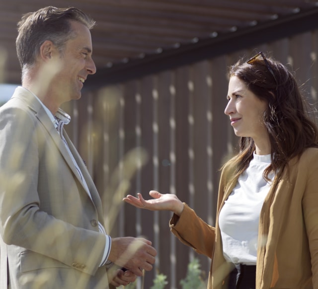 Två personer som har ett stående möte utomhus.
