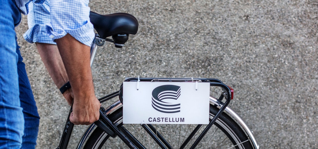 Person vid cykel som har en Castellum-skylt på pakethållaren.