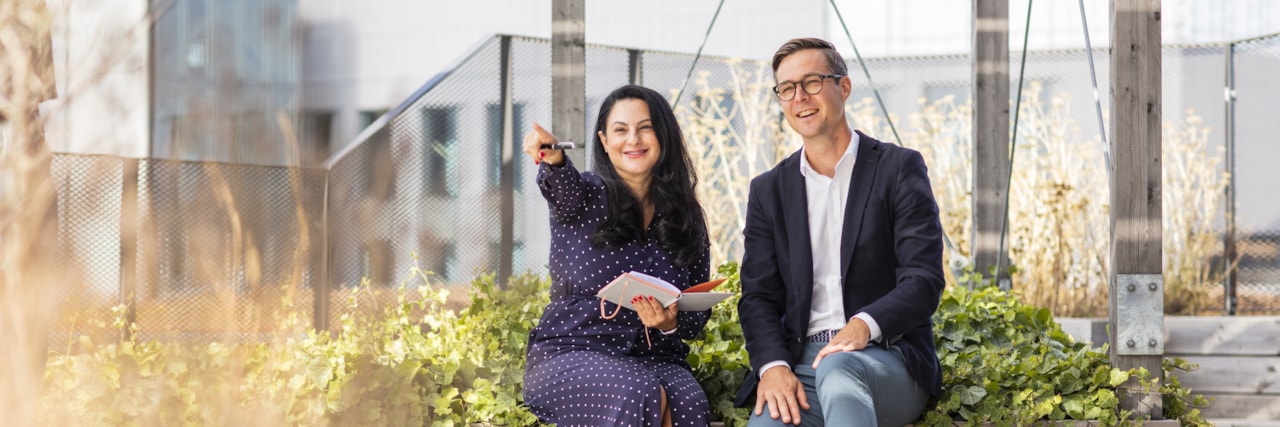Två personer som sitter på en bänk på en takterrass.