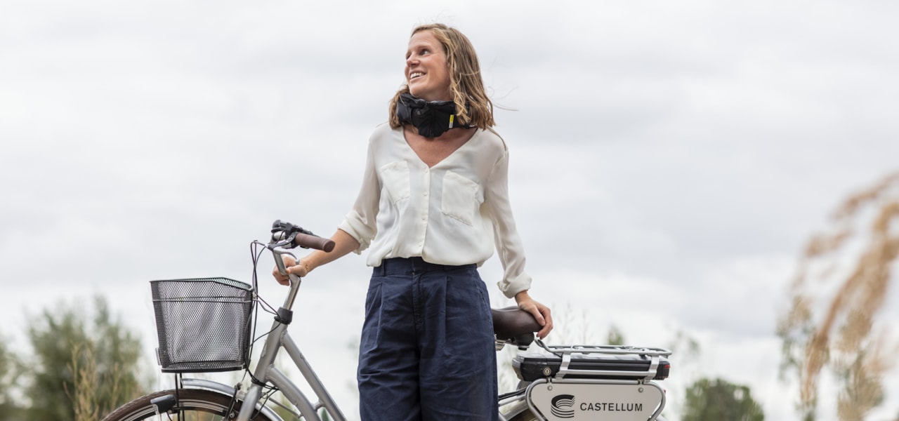 En person som lutar sig mot en cykel med Castellums logga.