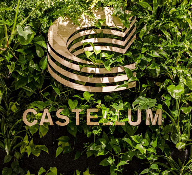 Castellums logga mot en växtvägg.