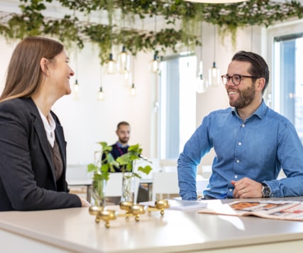 Två personer samtalar vid ett bord.