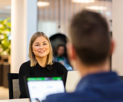 Två personer som sitter mittemot varandra med varsin dator.