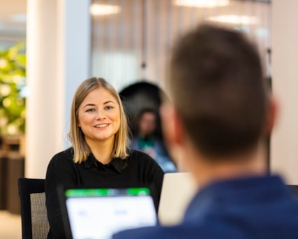 Två personer som sitter mittemot varandra med varsin dator.