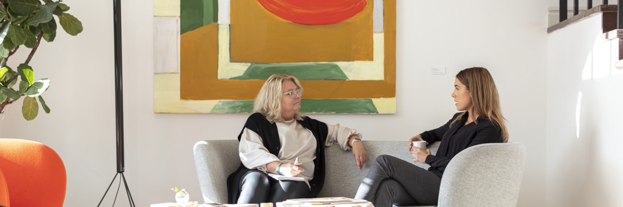 Två personer samtalar i en soffa.