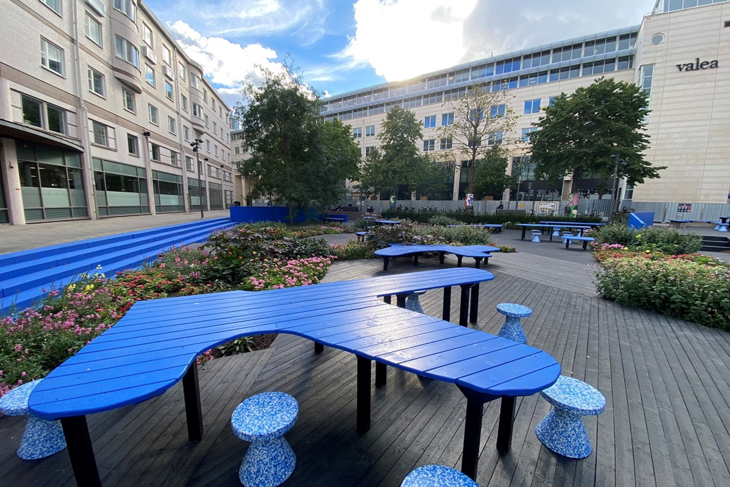 Innergård med blå sittmöbler och bord.