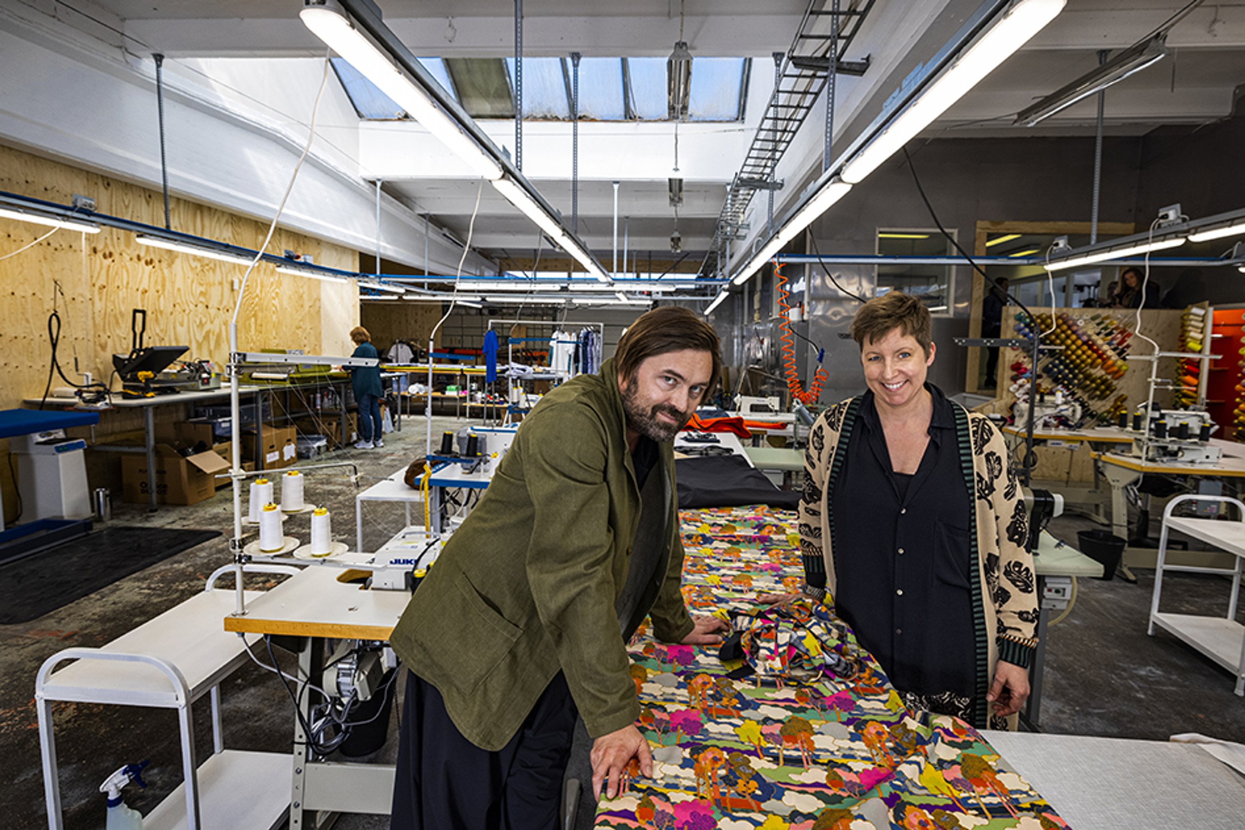 Två personer vid ett bord med textilier.