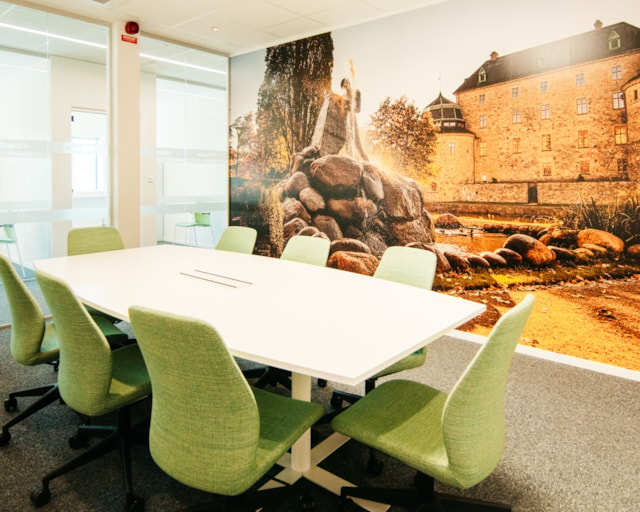 Litet konferensrum med gröna stolar och fototapet med Örebro slott