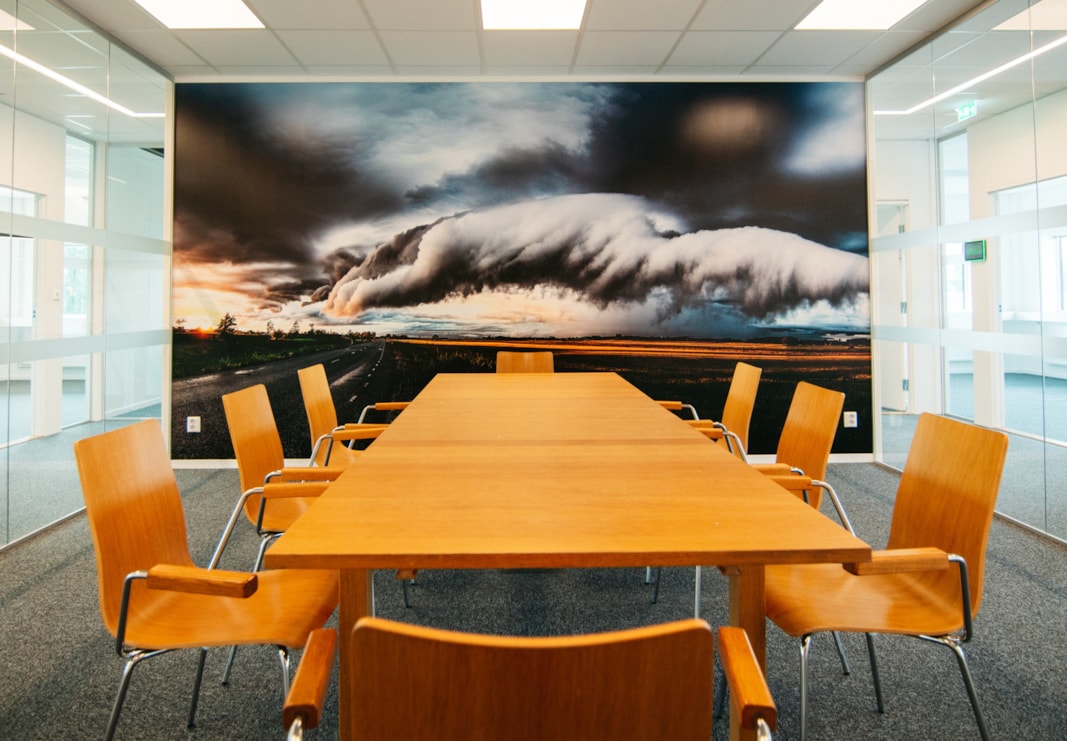 Konferensrum med orangefärgade möbler och fototapet med åskmoln