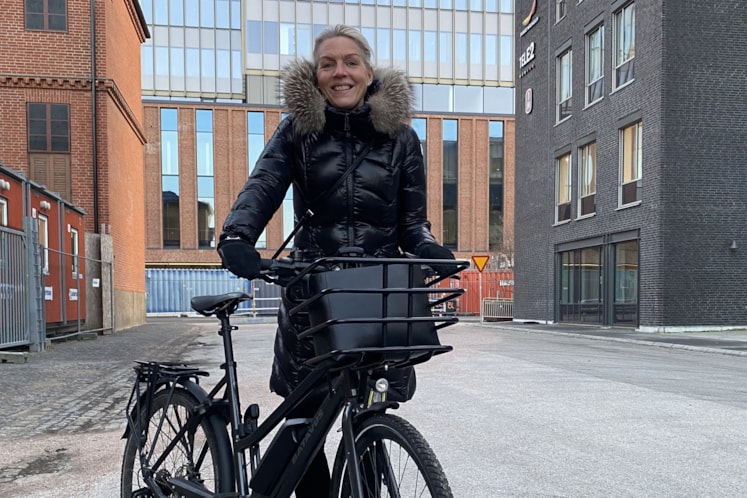 Medarbetare Helen Greve står bredvid sin cykel