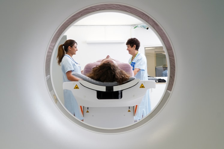 Patient och personal vid magnetröntgen.