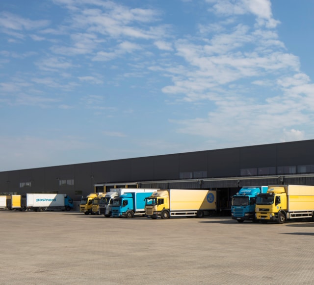 Lastbilar utanför logistikfastighet.